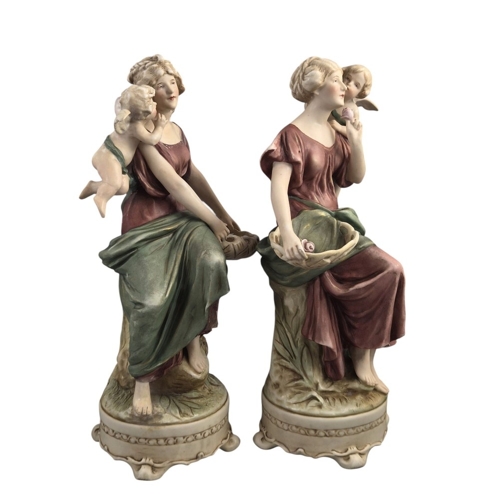 A pair of Royal Dux Art Nouveau porcelain figurines depicting classical maidens with winged cherubs and openwork baskets. View V