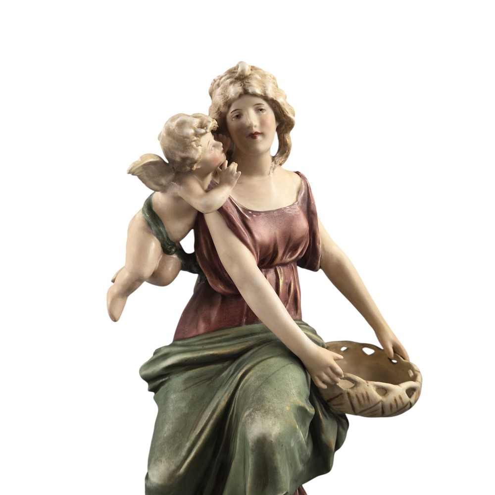 A pair of Royal Dux Art Nouveau porcelain figurines depicting classical maidens with winged cherubs and openwork baskets. View VI