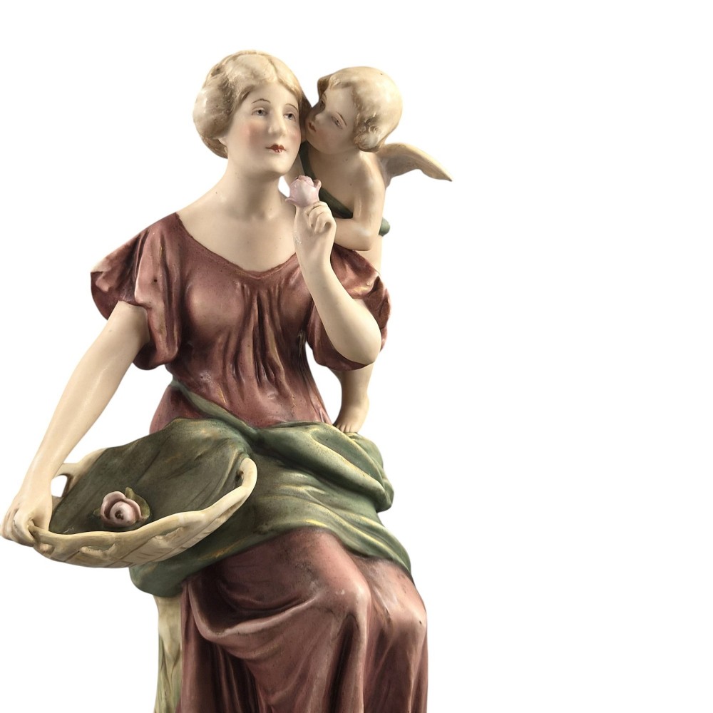 A pair of Royal Dux Art Nouveau porcelain figurines depicting classical maidens with winged cherubs and openwork baskets. View X