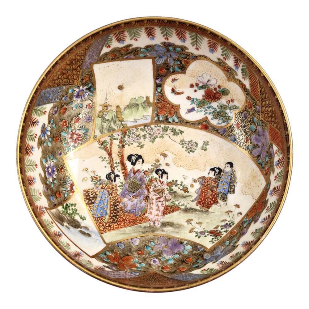 An antique Meiji period Japanese Satsuma earthenware bowl featuring hand-painted floral panels and gold detailing, elevated on a carved dark wooden base. View IX