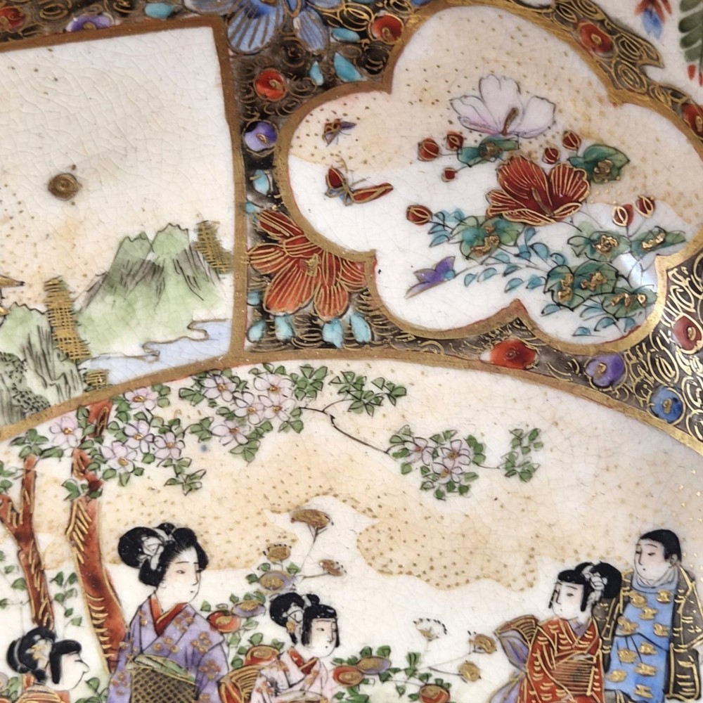 An antique Meiji period Japanese Satsuma earthenware bowl featuring hand-painted floral panels and gold detailing, elevated on a carved dark wooden base. View XII