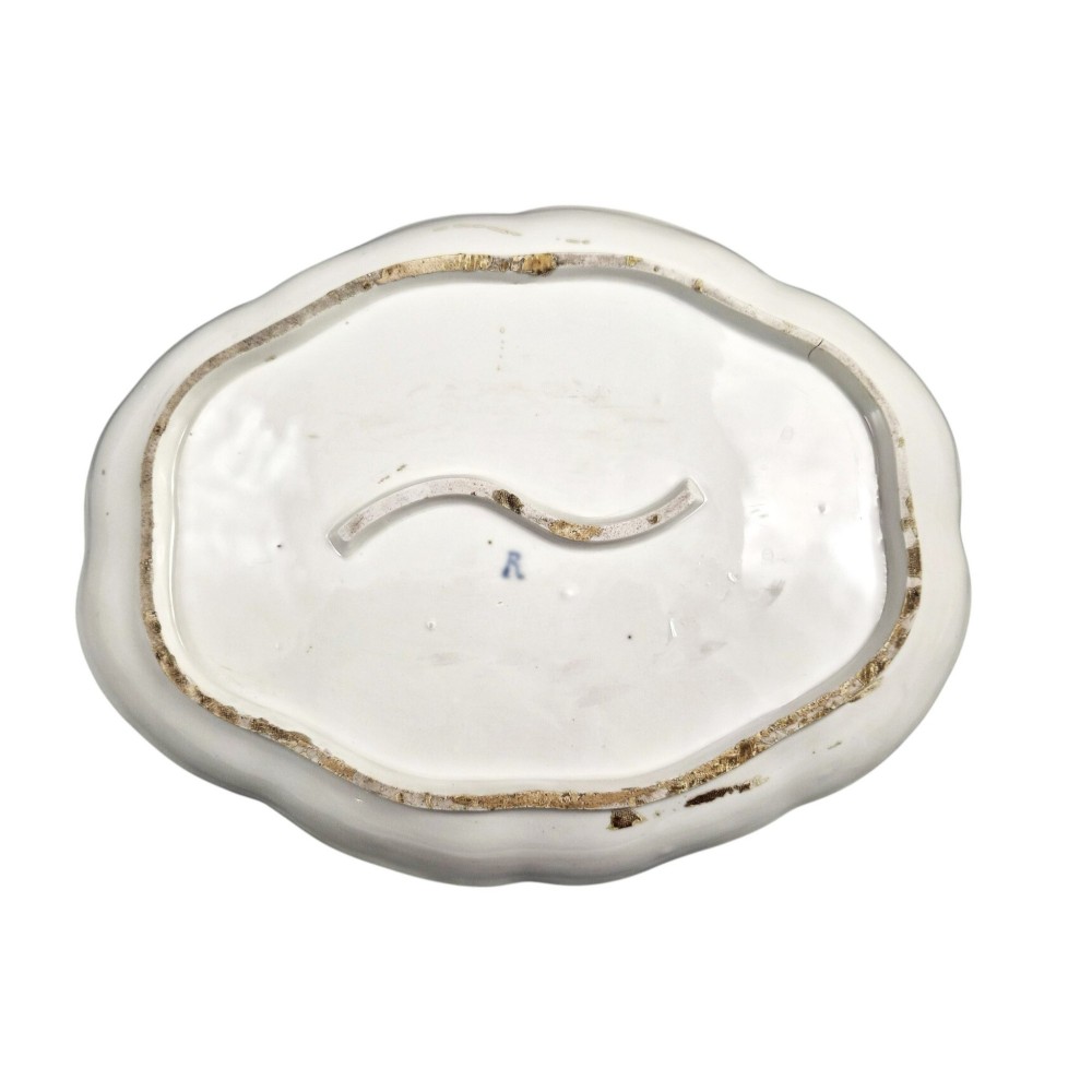 An oval 18th-century French porcelain tray featuring a hand-painted pastoral scene bordered by pink ribbon decoration and a scalloped gilt edge. View V