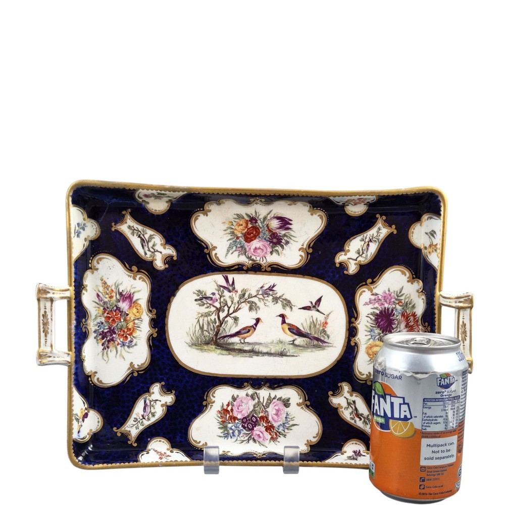 A rectangular mid-19th-century English porcelain tray featuring a dark cobalt blue ground, hand-painted exotic birds in a central oval vignette, floral reserves, and gilt handles. View XII