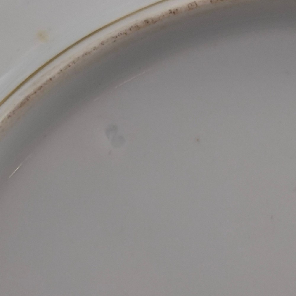 A white round porcelain plate featuring a thick cobalt blue scalloped border and a gilded Imperial monogram topped with a crown. View VIII