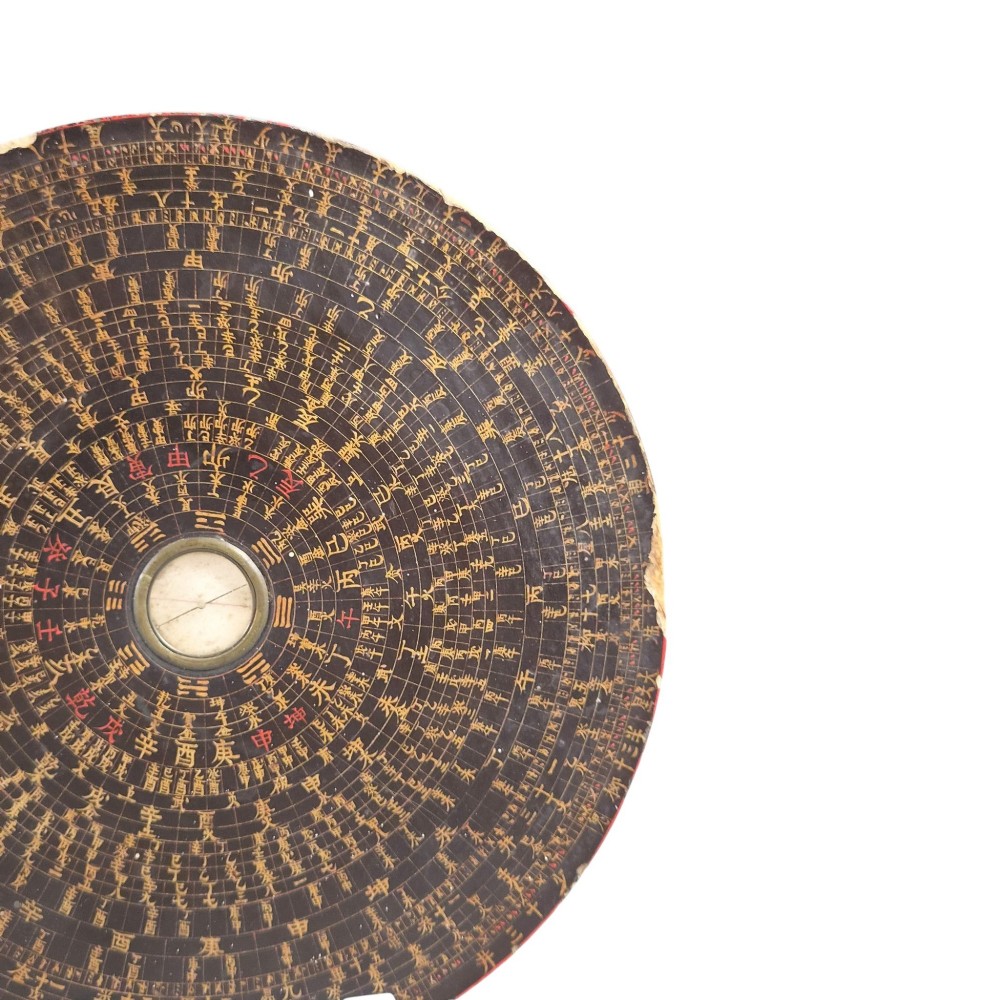 A circular antique Chinese Luopan geomantic compass crafted from dark lacquered wood featuring multiple concentric rings of gilded Chinese characters and a central brass magnetic dial. View V