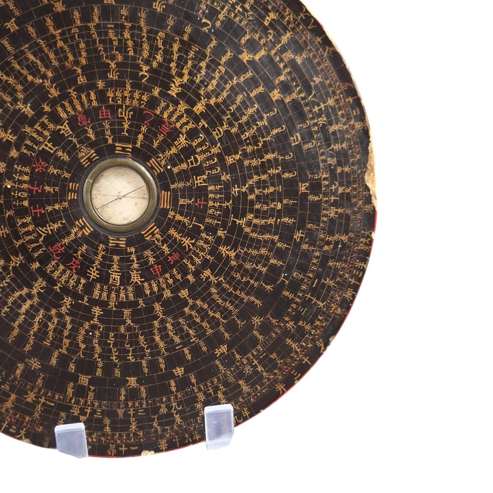 A circular antique Chinese Luopan geomantic compass crafted from dark lacquered wood featuring multiple concentric rings of gilded Chinese characters and a central brass magnetic dial. View VI