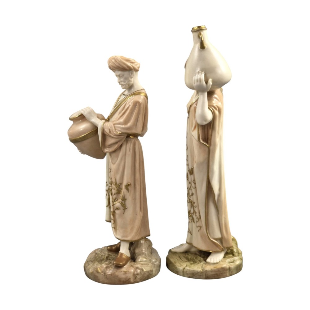 A pair of Royal Worcester blush ivory porcelain figures depicting a male and female Cairo water carrier with gilded accents. View II