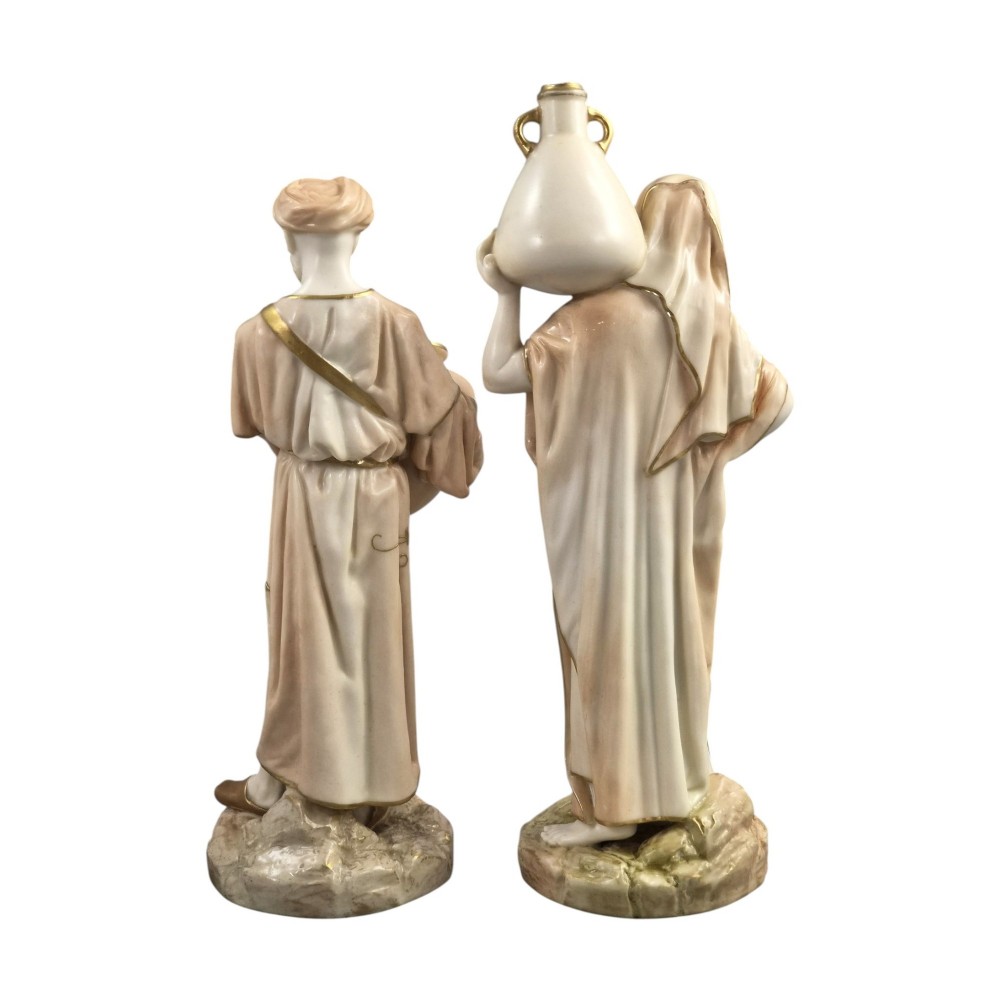 A pair of Royal Worcester blush ivory porcelain figures depicting a male and female Cairo water carrier with gilded accents. View III
