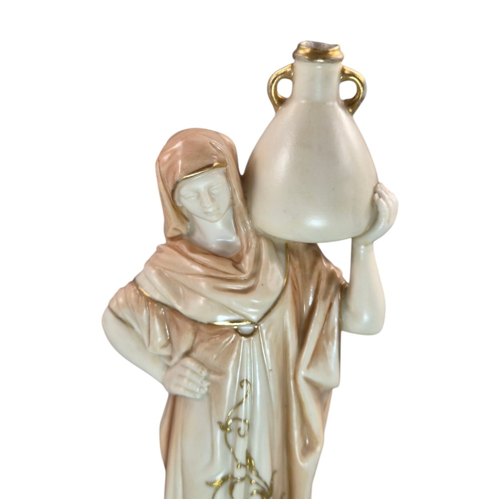 A pair of Royal Worcester blush ivory porcelain figures depicting a male and female Cairo water carrier with gilded accents. View X