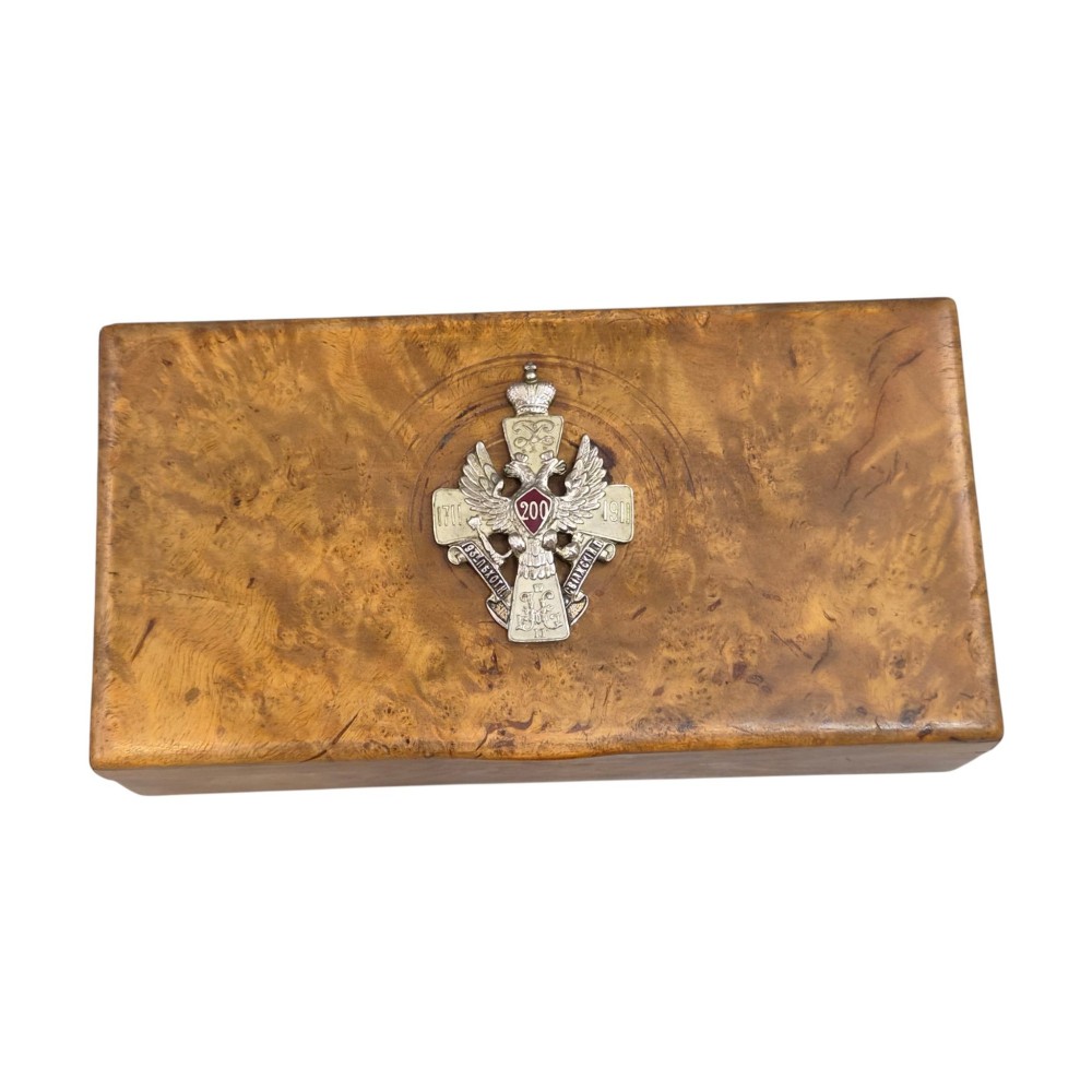 A rectangular Karelian birch box featuring a prominent silver and enamel Imperial Russian regimental badge mounted centrally on the lid. View II