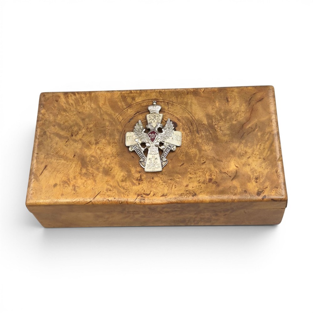 A rectangular Karelian birch box featuring a prominent silver and enamel Imperial Russian regimental badge mounted centrally on the lid.