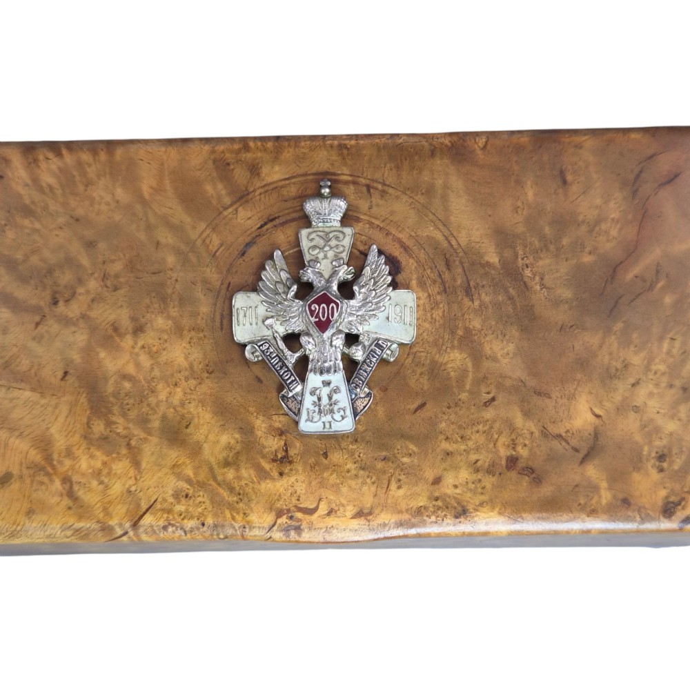 A rectangular Karelian birch box featuring a prominent silver and enamel Imperial Russian regimental badge mounted centrally on the lid. View III