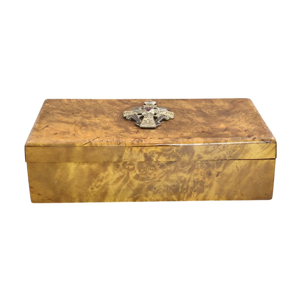 A rectangular Karelian birch box featuring a prominent silver and enamel Imperial Russian regimental badge mounted centrally on the lid. View V