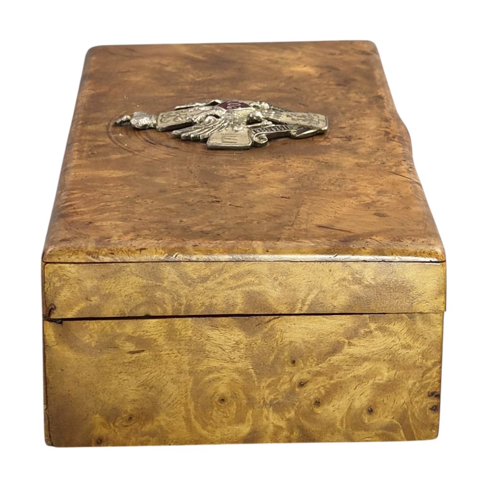 A rectangular Karelian birch box featuring a prominent silver and enamel Imperial Russian regimental badge mounted centrally on the lid. View VIII