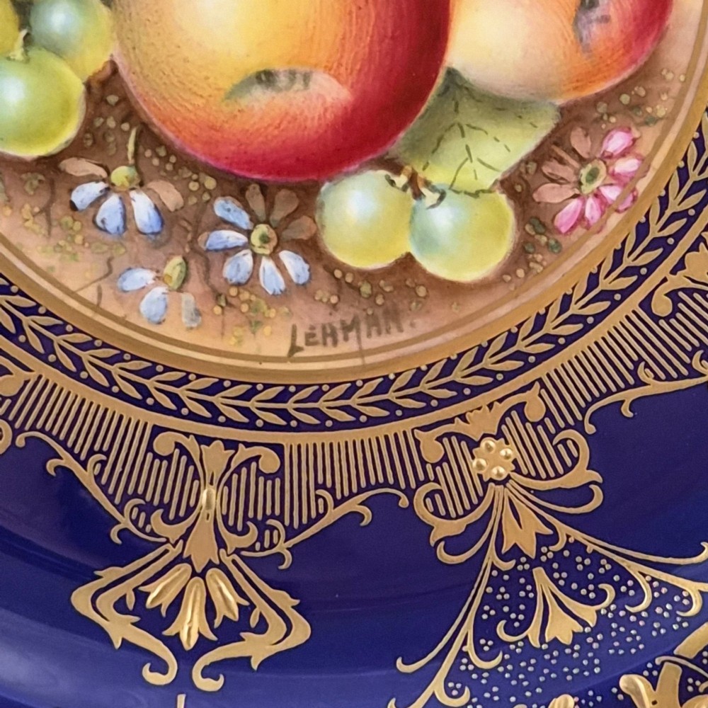 A circular Royal Worcester porcelain cabinet plate featuring a hand-painted fruit still life surrounded by a deep cobalt blue border decorated with intricate gold gilding. View IV