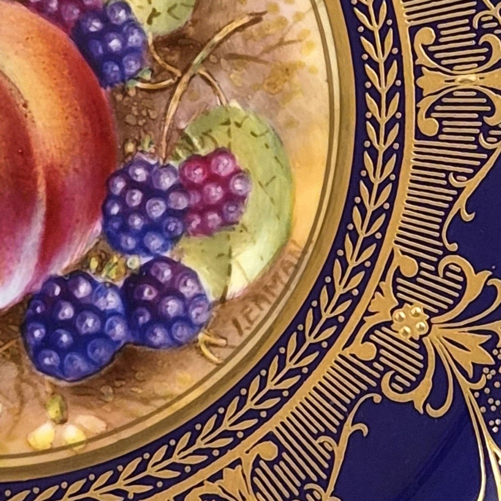 A circular porcelain cabinet plate featuring a central hand-painted still life of peaches and blackberries, surrounded by a broad cobalt blue border adorned with intricate gold gilding. View III