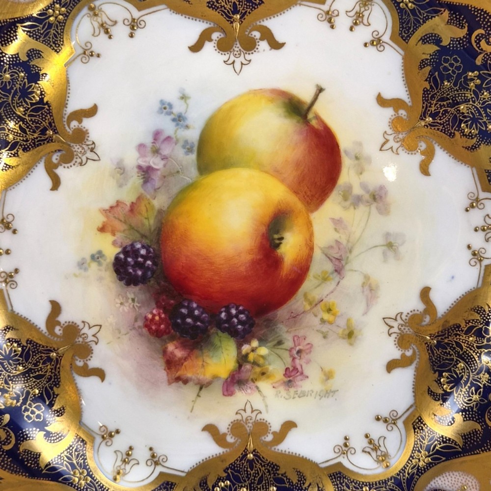 A circular porcelain cabinet plate featuring a central hand-painted fruit study surrounded by an ornate cobalt blue and heavily gilded scalloped rim. View III