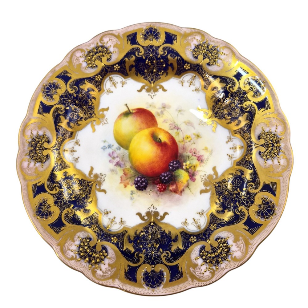 A circular Royal Worcester porcelain cabinet plate featuring hand-painted apples and berries in the centre surrounded by a cobalt blue border with heavy gold gilding. View IX