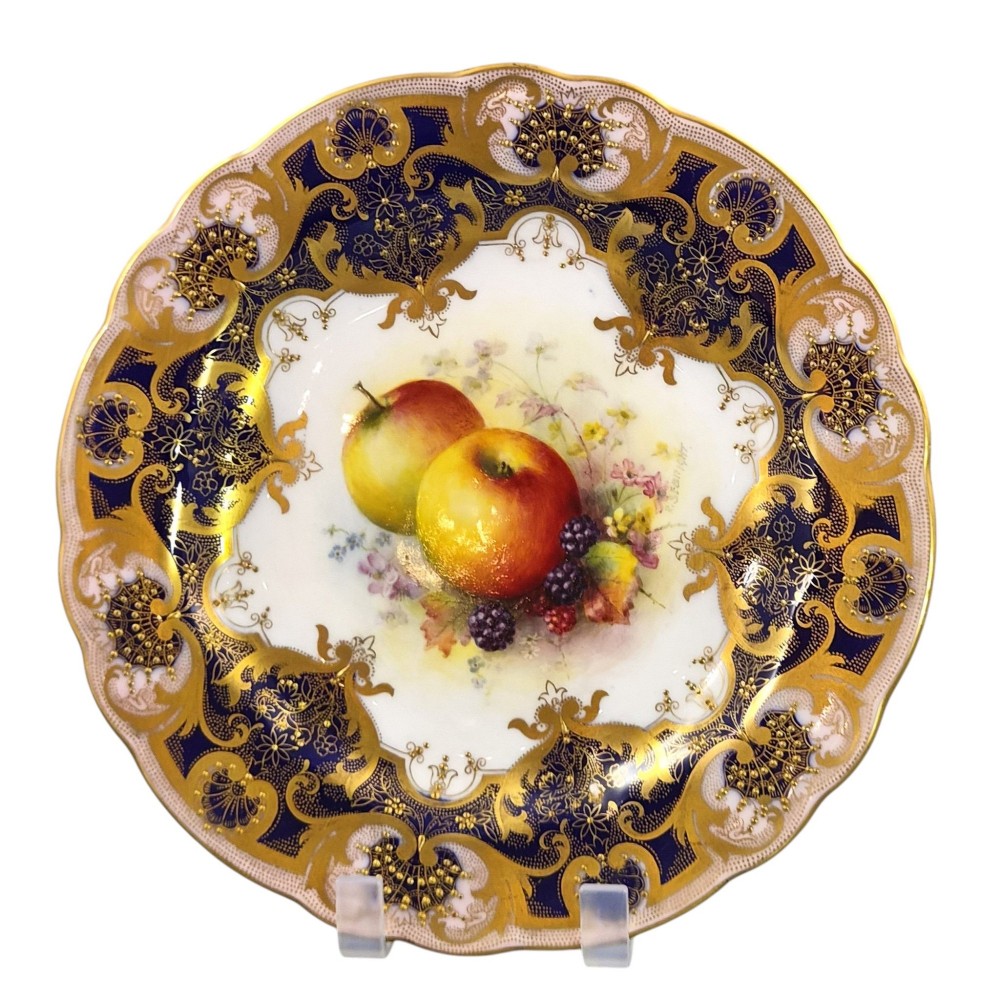 A circular Royal Worcester porcelain cabinet plate featuring hand-painted apples and berries in the centre surrounded by a cobalt blue border with heavy gold gilding. View XI