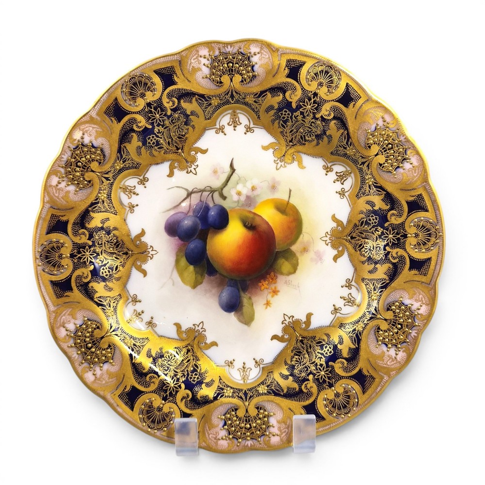 A circular porcelain cabinet plate featuring a central hand-painted motif of apples and grapes surrounded by an ornate cobalt blue and heavily gilded rococo border. View II