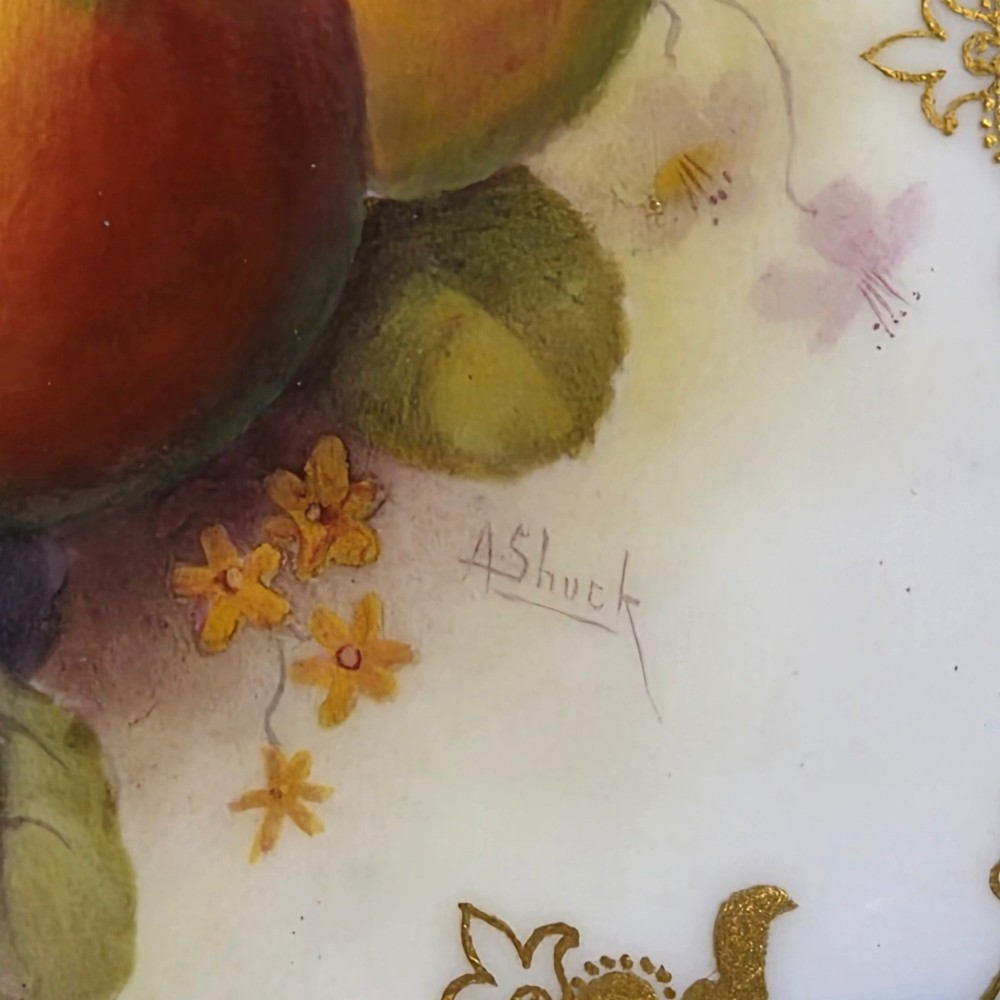 A circular porcelain cabinet plate featuring a central hand-painted motif of apples and grapes surrounded by an ornate cobalt blue and heavily gilded rococo border. View IV