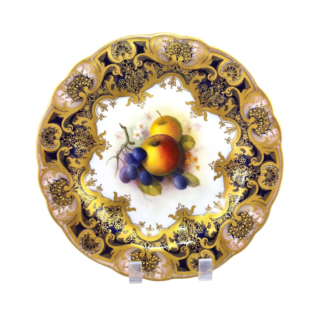 A circular porcelain cabinet plate featuring a central hand-painted motif of apples and grapes surrounded by an ornate cobalt blue and heavily gilded rococo border. View VIII