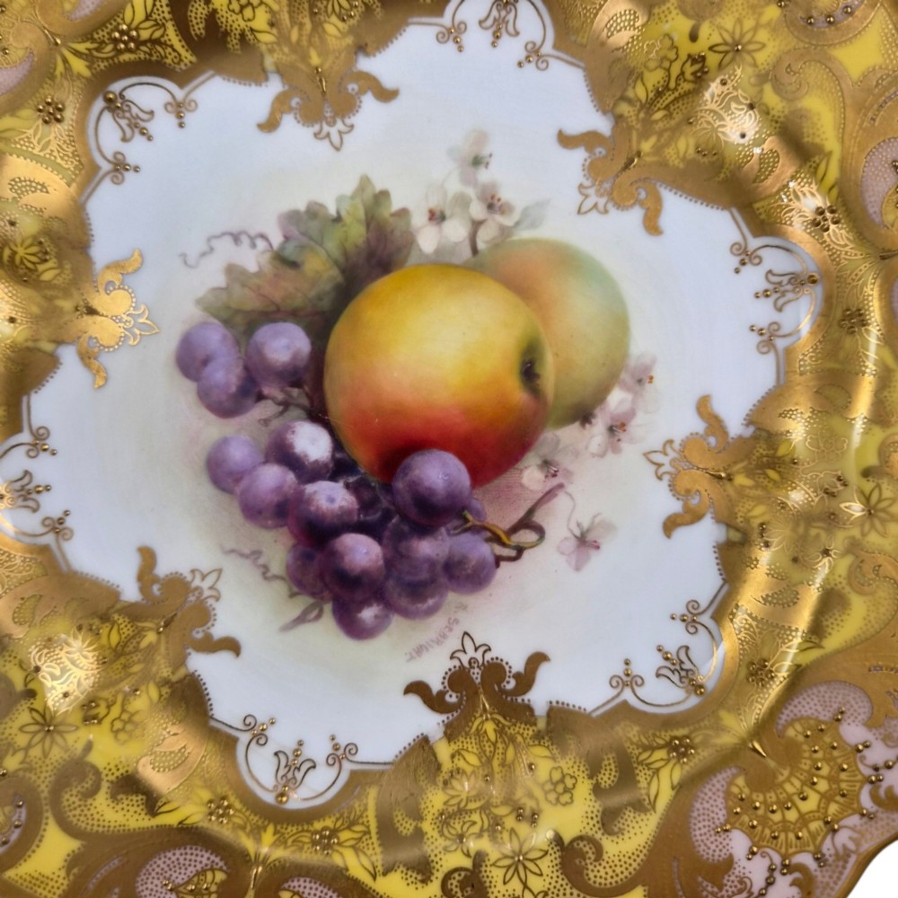 A circular Royal Worcester ceramic cabinet plate featuring a central hand-painted motif of apples and grapes surrounded by a gold gilt and yellow scrollwork border. View III