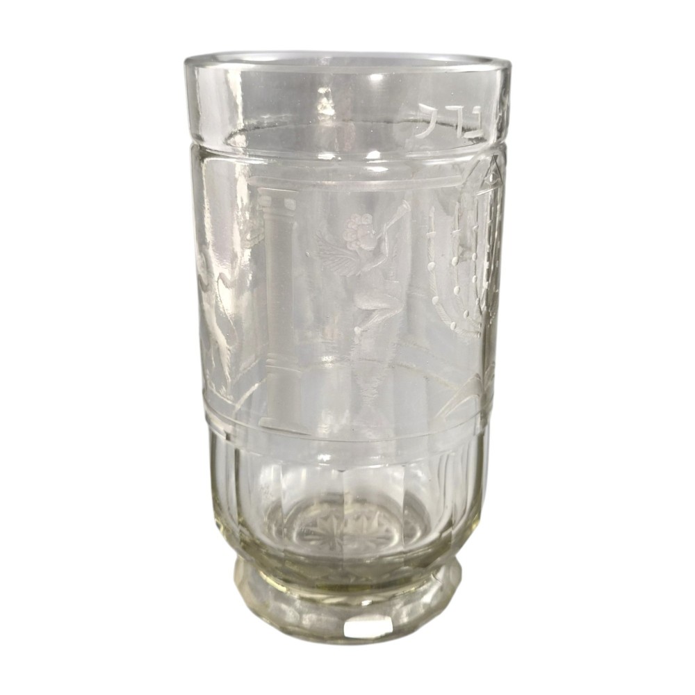 A large clear glass beaker featuring detailed wheel-engraved ceremonial iconography, vertical fluted panels near the lower rim, and a faceted base. View III