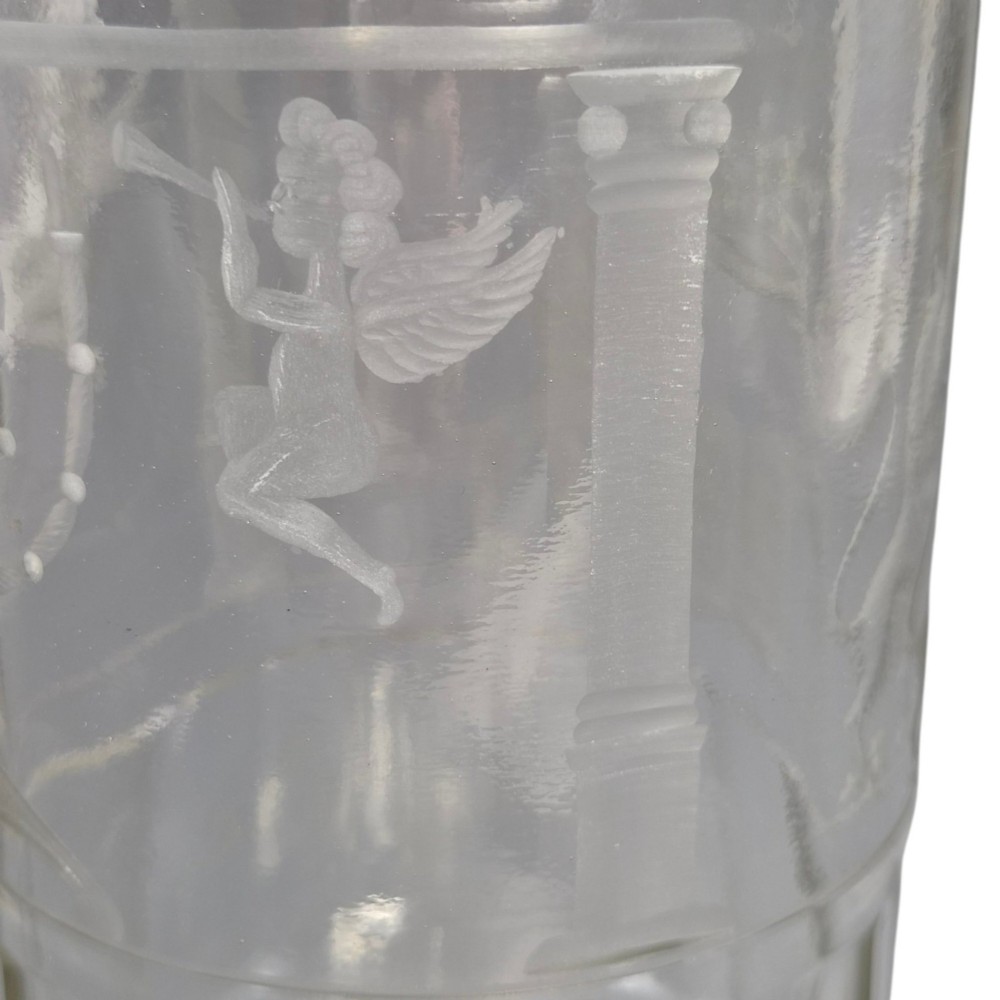 A large clear glass beaker featuring detailed wheel-engraved ceremonial iconography, vertical fluted panels near the lower rim, and a faceted base. View VII