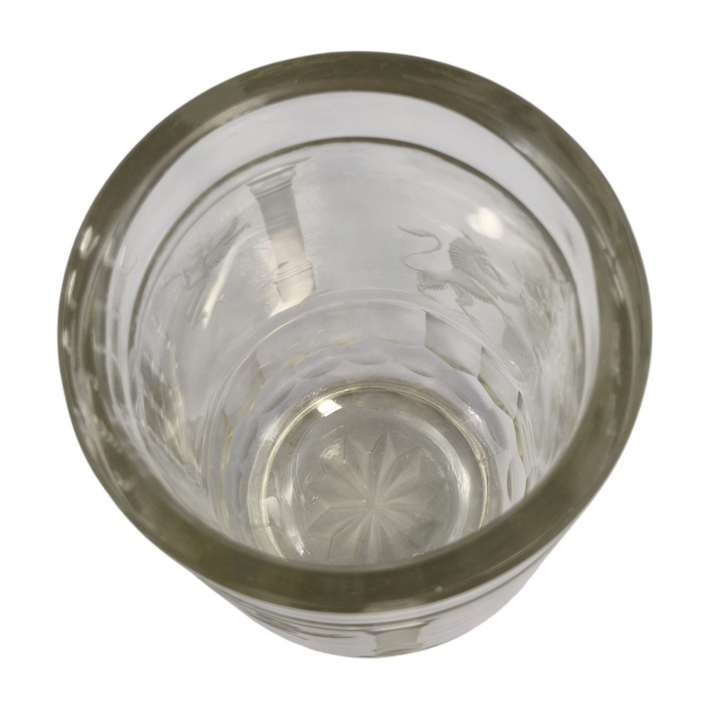 A large clear glass beaker featuring detailed wheel-engraved ceremonial iconography, vertical fluted panels near the lower rim, and a faceted base. View XI