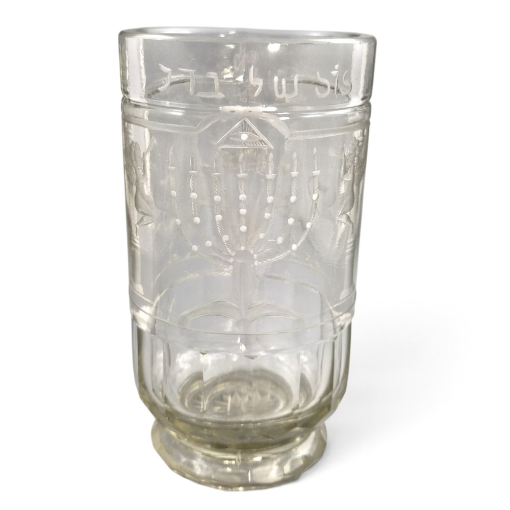 A large clear glass beaker featuring detailed wheel-engraved ceremonial iconography, vertical fluted panels near the lower rim, and a faceted base. View XIV