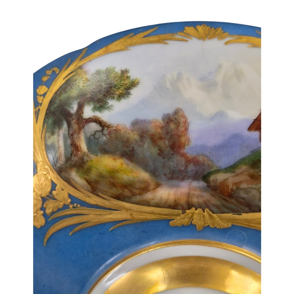 A cobalt blue and gilt porcelain tazza elevated on a pedestal base, adorned with a hand-painted winter landscape cartouche. View XII