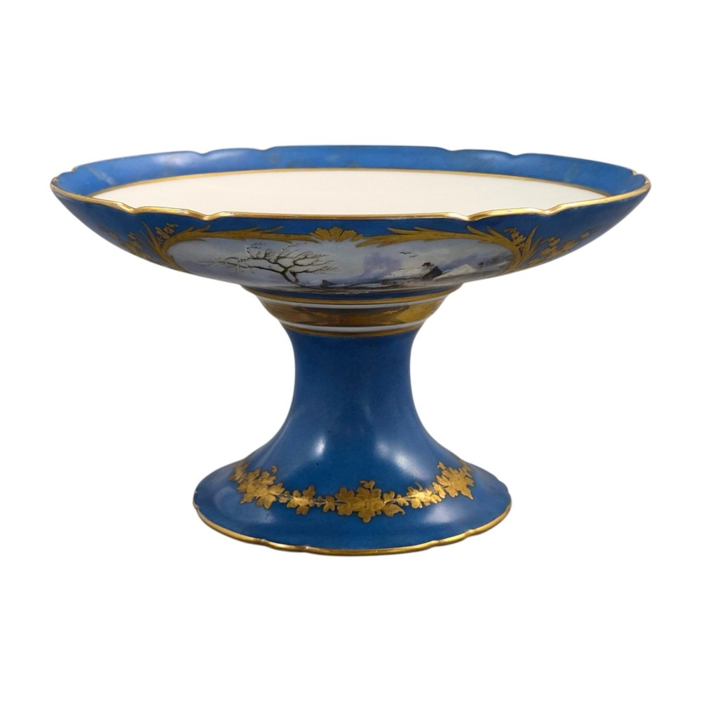A cobalt blue and gilt porcelain tazza elevated on a pedestal base, adorned with a hand-painted winter landscape cartouche. View XIV