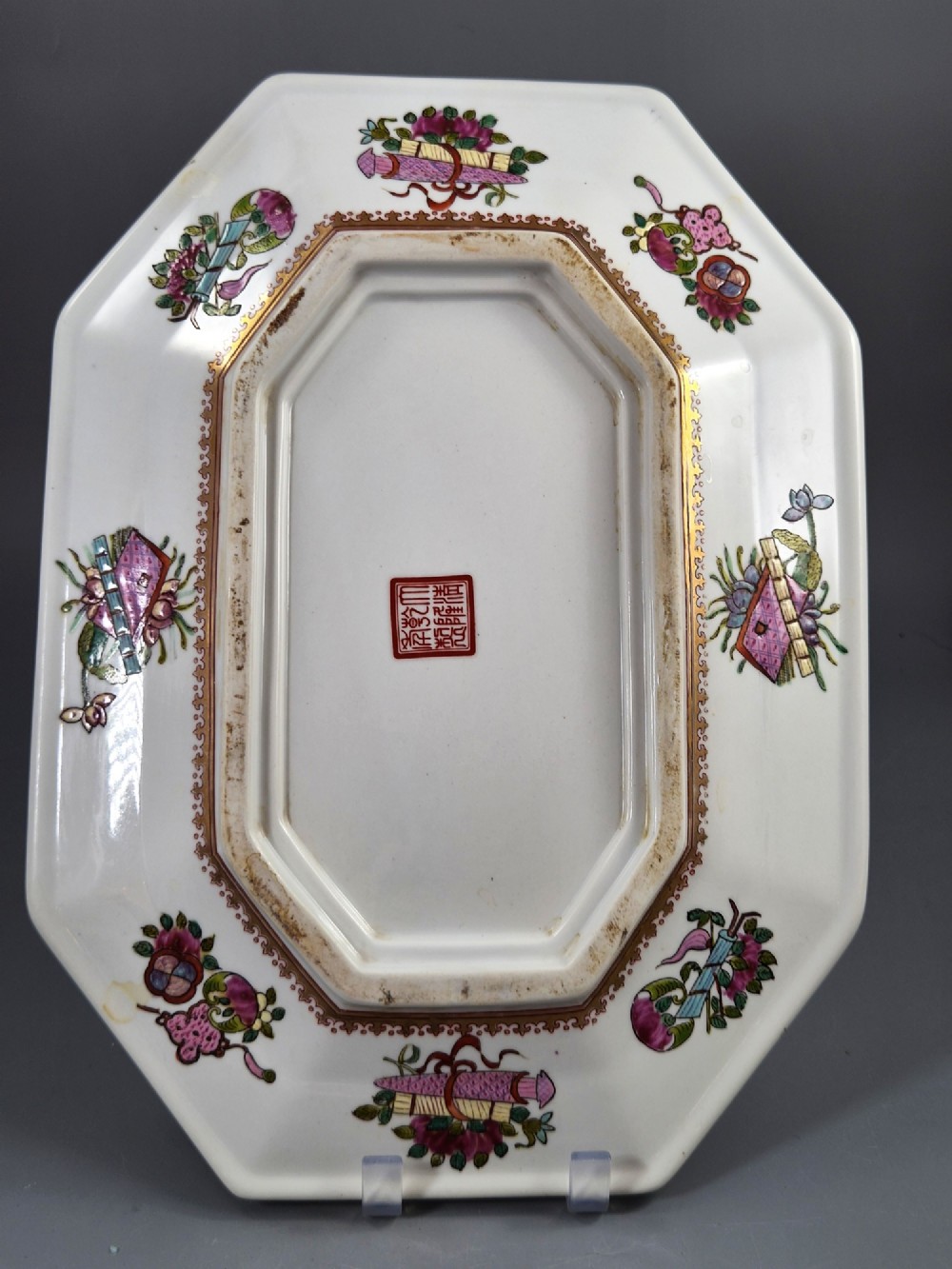 An octagonal Chinese Famille Rose porcelain tray depicting figures in a garden court scene surrounded by floral and butterfly borders. View V