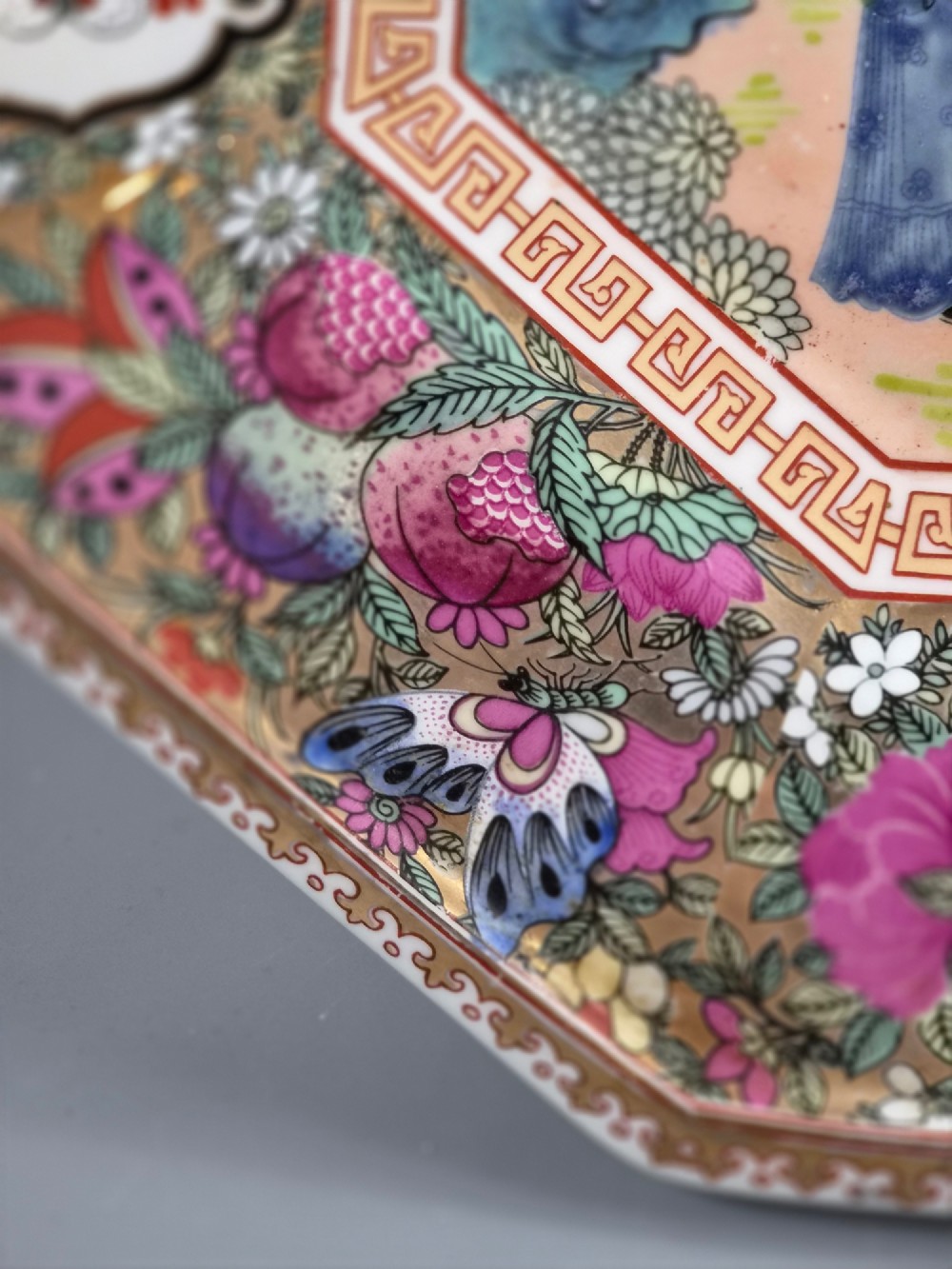 An octagonal Chinese Famille Rose porcelain tray depicting figures in a garden court scene surrounded by floral and butterfly borders. View VII
