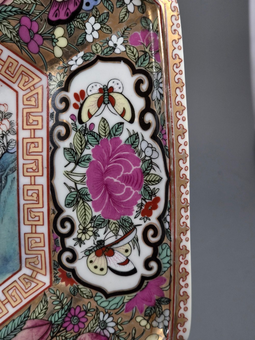 An octagonal Chinese Famille Rose porcelain tray depicting figures in a garden court scene surrounded by floral and butterfly borders. View IX