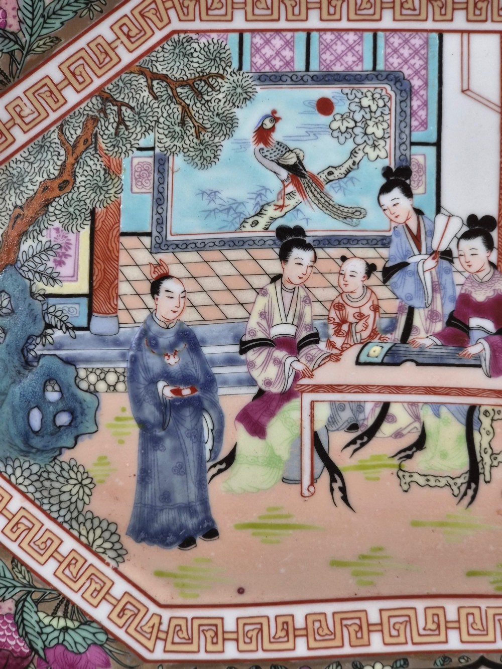 An octagonal Chinese Famille Rose porcelain tray depicting figures in a garden court scene surrounded by floral and butterfly borders. View X