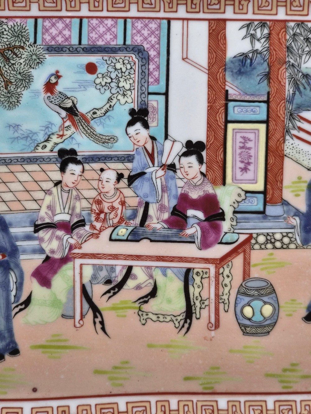 An octagonal Chinese Famille Rose porcelain tray depicting figures in a garden court scene surrounded by floral and butterfly borders. View XI