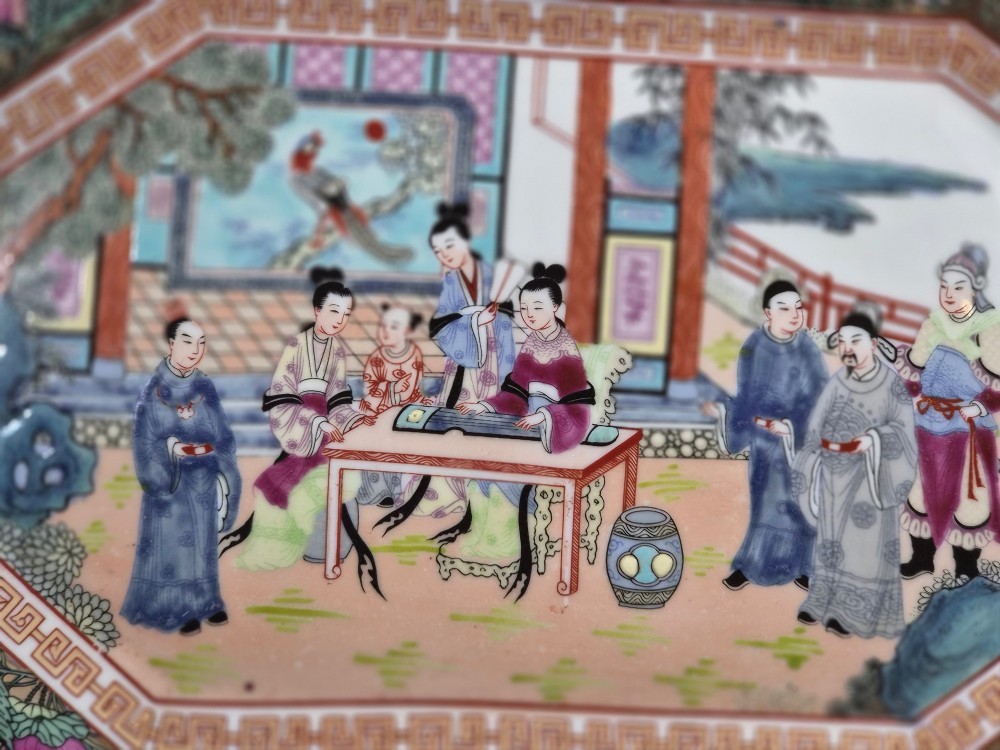 An octagonal Chinese Famille Rose porcelain tray depicting figures in a garden court scene surrounded by floral and butterfly borders. View XII