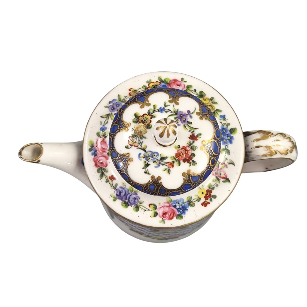 An 18th-century French Sevres soft-paste porcelain litron teapot decorated with hand-painted floral cartouches, gilding, and cobalt blue borders. View V