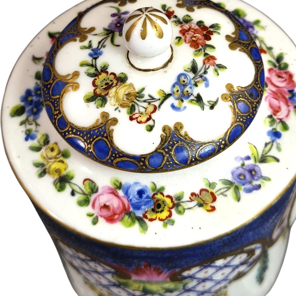 An 18th-century French Sevres soft-paste porcelain litron teapot decorated with hand-painted floral cartouches, gilding, and cobalt blue borders. View X