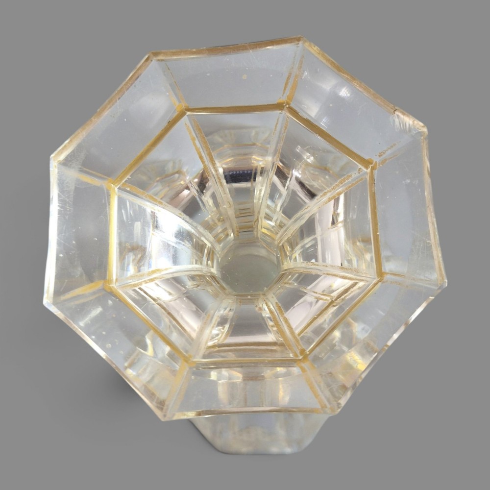 A clear Bohemian crystal romer goblet featuring wheel-engraved grapevine motifs, a faceted stem, and gilt highlight accents on a hexagonal foot. View X