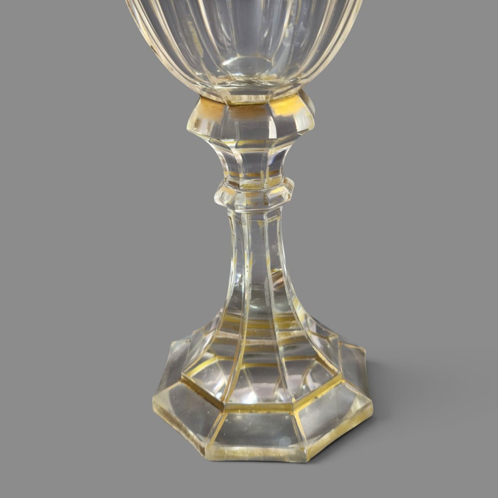 A clear Bohemian crystal romer goblet featuring wheel-engraved grapevine motifs, a faceted stem, and gilt highlight accents on a hexagonal foot. View XI
