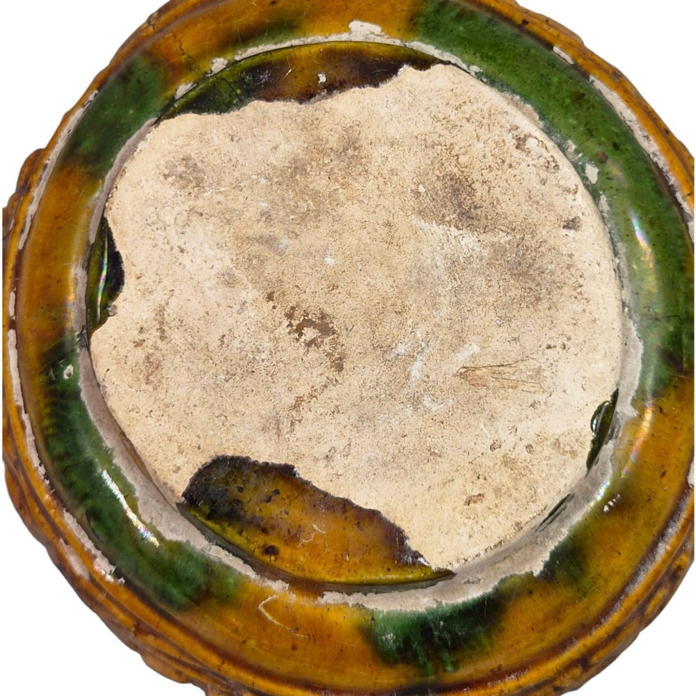 A squat antique Chinese ceramic water vessel featuring a green glazed upper shoulder, a square rim, and an amber-glazed moulded floral band around the middle. View VII