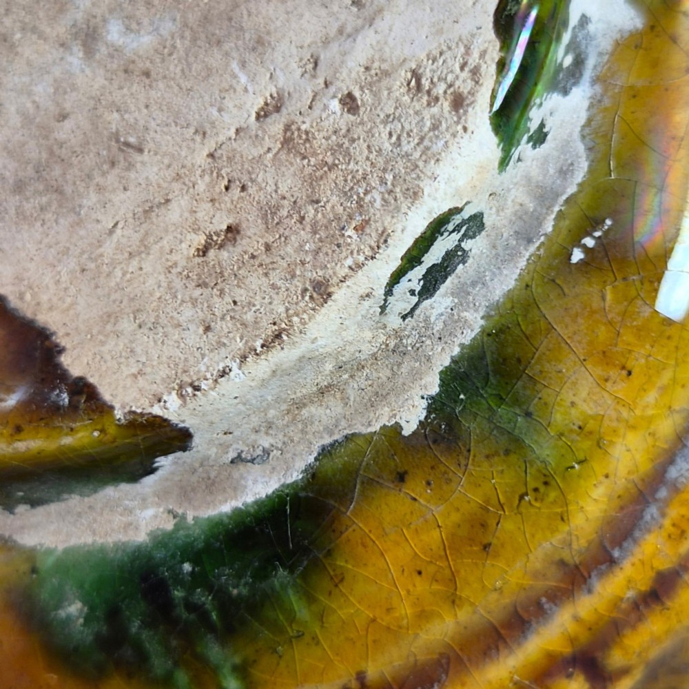 A squat antique Chinese ceramic water vessel featuring a green glazed upper shoulder, a square rim, and an amber-glazed moulded floral band around the middle. View VIII