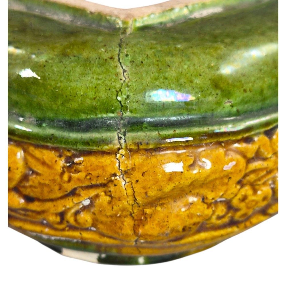 A squat antique Chinese ceramic water vessel featuring a green glazed upper shoulder, a square rim, and an amber-glazed moulded floral band around the middle. View XI