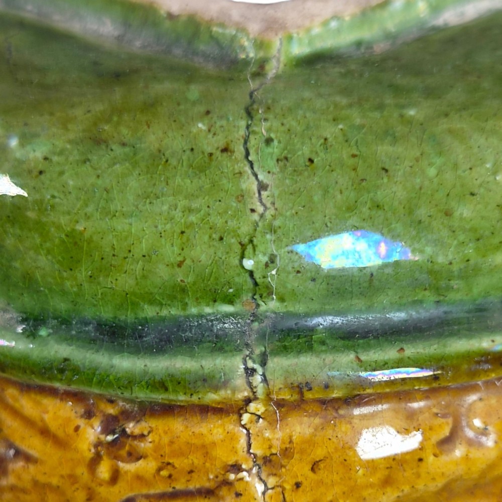 A squat antique Chinese ceramic water vessel featuring a green glazed upper shoulder, a square rim, and an amber-glazed moulded floral band around the middle. View XII