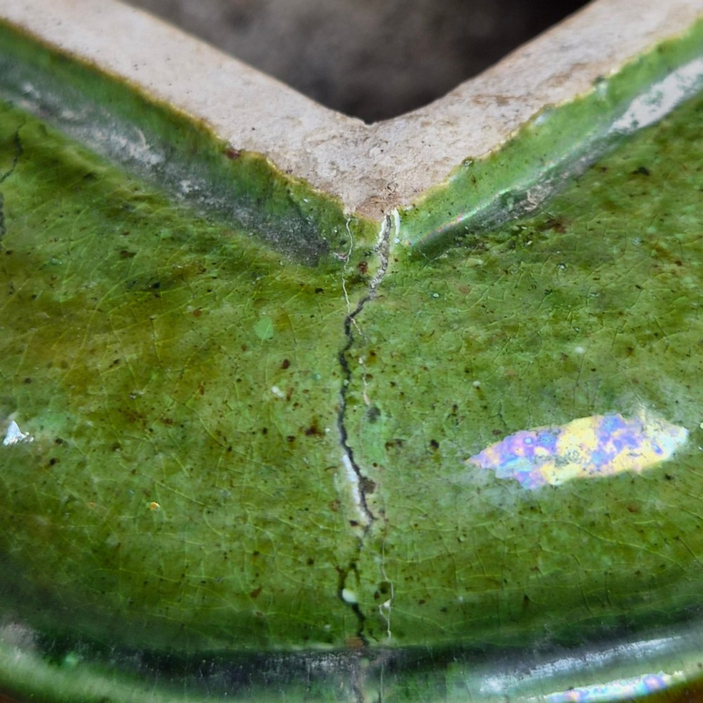 A squat antique Chinese ceramic water vessel featuring a green glazed upper shoulder, a square rim, and an amber-glazed moulded floral band around the middle. View XIII