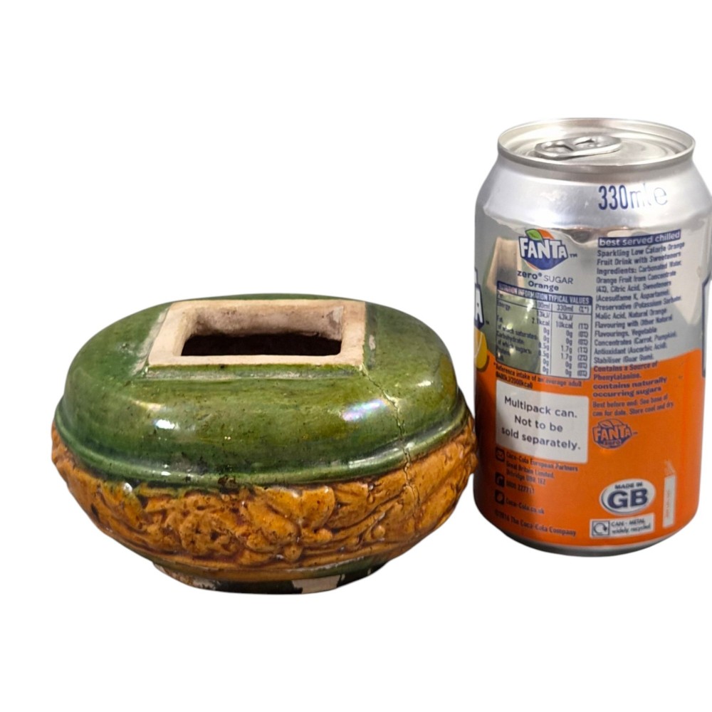 A squat antique Chinese ceramic water vessel featuring a green glazed upper shoulder, a square rim, and an amber-glazed moulded floral band around the middle. View XIV