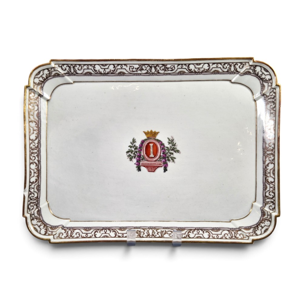 An eighteenth-century rectangular white porcelain serving tray featuring shaped corners, delicate gilded scrollwork borders, and a central hand-painted crowned monogram.